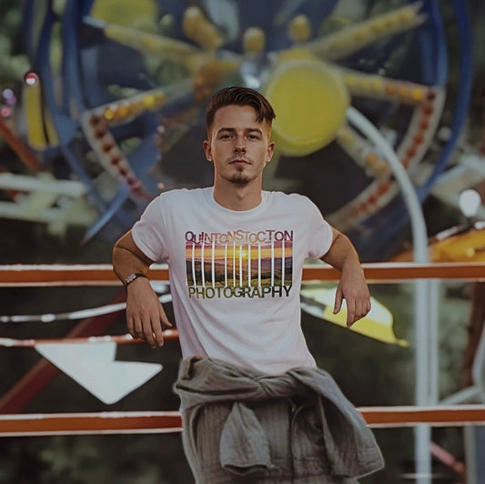 Man wearing a t-shirt with 'Quinton Stocton Photography' design in front of a Ferris wheel. Posed like a famous movie scene.
