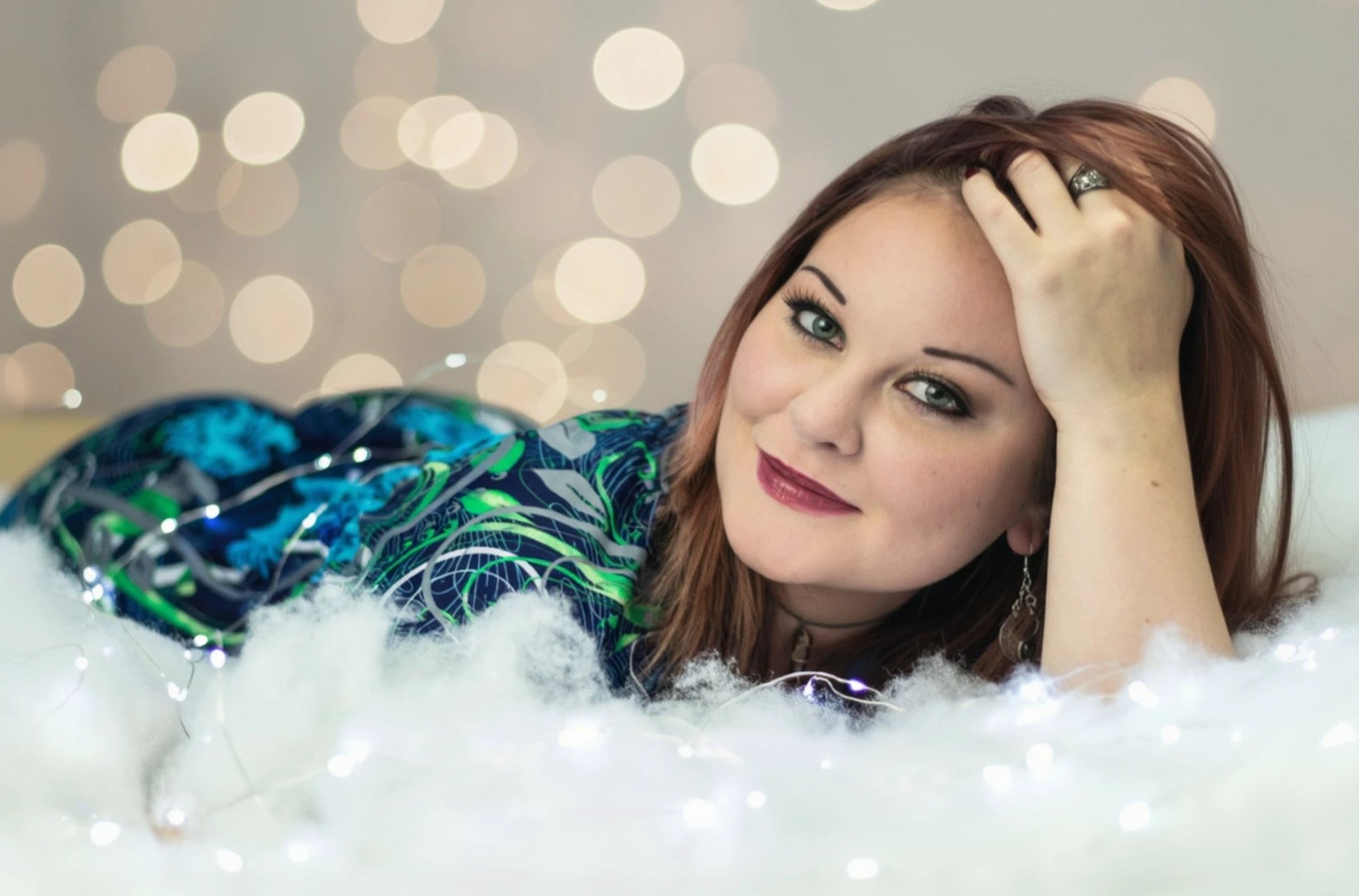 Woman lying in a clouds with string lights for effect in the background